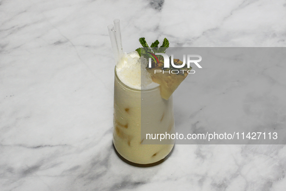 A cocktail ''Pina colada'' is sitting on a bright background. 