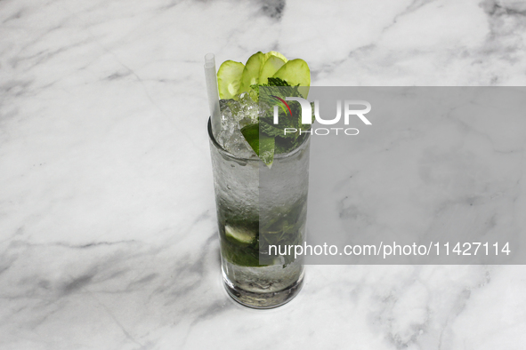 A cocktail ''Handrix Mojito'' is sitting on a bright background. 