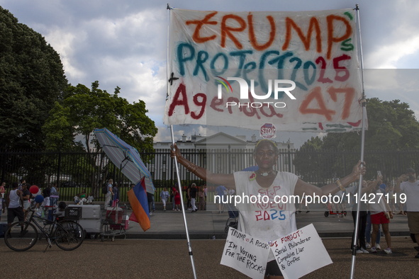 An activist is showing a sign with the words "Trump's Project 2025 Agenda 47" among other informative texts in front of the White House in W...