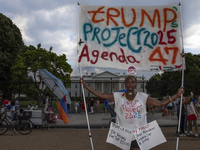 An activist is showing a sign with the words "Trump's Project 2025 Agenda 47" among other informative texts in front of the White House in W...