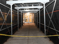 Police tape is blocking the entrance to the building. A man is being shot in the head and killed in Bronx, New York, United States, on July...