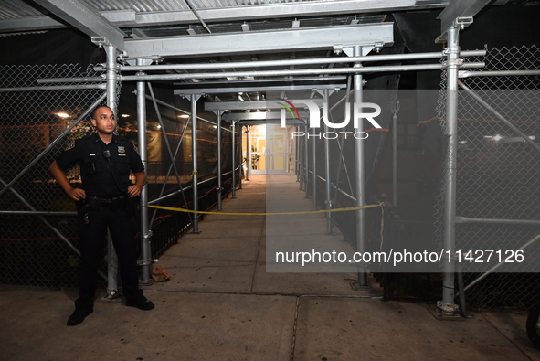 A police officer is guarding the crime scene. A man is being shot in the head and killed in Bronx, New York, United States, on July 21, 2024...