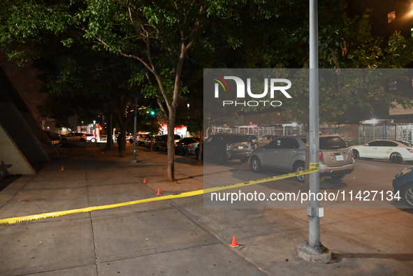 Evidence cones and crime scene tape are marking the crime scene. A male is in critical condition after being shot in an apartment building i...