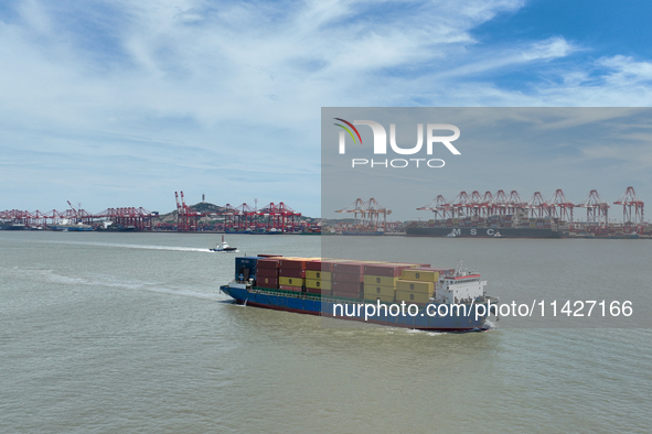 A large container ship is leaving the dock at Yangshan Port in Shanghai, China, on July 21, 2024. 