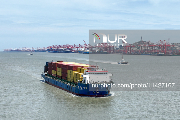 A large container ship is leaving the dock at Yangshan Port in Shanghai, China, on July 21, 2024. 