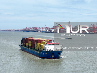 A large container ship is leaving the dock at Yangshan Port in Shanghai, China, on July 21, 2024. (