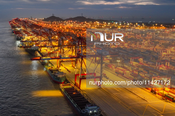 A photo is showing the working scene at the wharf of Shanghai Yangshan Port in Shanghai, China, on July 21, 2024, in the evening. 