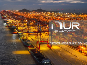 A photo is showing the working scene at the wharf of Shanghai Yangshan Port in Shanghai, China, on July 21, 2024, in the evening. (