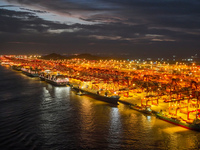 A photo is showing the working scene at the wharf of Shanghai Yangshan Port in Shanghai, China, on July 21, 2024, in the evening. (