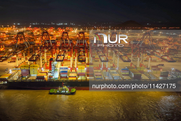 A photo is showing the working scene at the wharf of Shanghai Yangshan Port in Shanghai, China, on July 21, 2024, in the evening. 