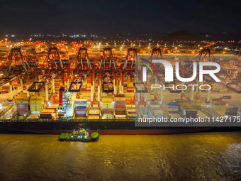 A photo is showing the working scene at the wharf of Shanghai Yangshan Port in Shanghai, China, on July 21, 2024, in the evening. (