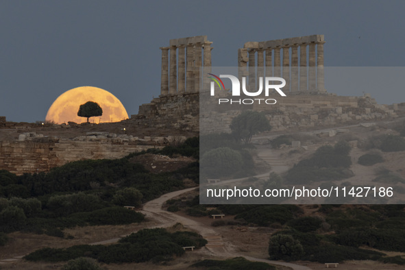 The Full Buck Moon rises behind the ancient Greek Temple of Poseidon on Cape Sounion in Greece on July 20, 2024 