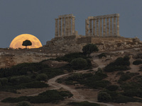 The Full Buck Moon rises behind the ancient Greek Temple of Poseidon on Cape Sounion in Greece on July 20, 2024 (