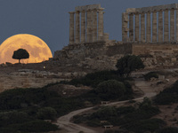 The Full Buck Moon rises behind the ancient Greek Temple of Poseidon on Cape Sounion in Greece on July 20, 2024 (