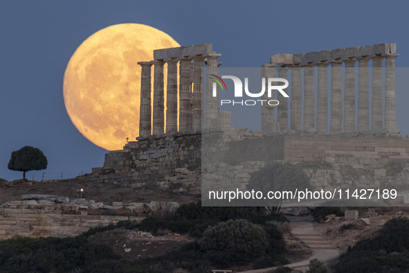 The Full Buck Moon rises behind the ancient Greek Temple of Poseidon on Cape Sounion in Greece on July 20, 2024 