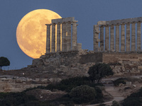 The Full Buck Moon rises behind the ancient Greek Temple of Poseidon on Cape Sounion in Greece on July 20, 2024 (