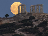 The Full Buck Moon rises behind the ancient Greek Temple of Poseidon on Cape Sounion in Greece on July 20, 2024 (