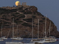 The Full Buck Moon rises behind the ancient Greek Temple of Poseidon on Cape Sounion in Greece on July 20, 2024 (