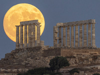 The Full Buck Moon rises behind the ancient Greek Temple of Poseidon on Cape Sounion in Greece on July 20, 2024 (