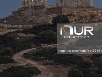 The Full Buck Moon rises behind the ancient Greek Temple of Poseidon on Cape Sounion in Greece on July 20, 2024 (