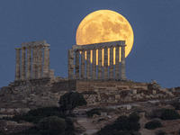 The Full Buck Moon rises behind the ancient Greek Temple of Poseidon on Cape Sounion in Greece on July 20, 2024 (