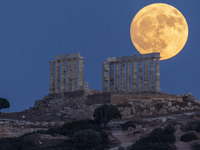 The Full Buck Moon rises behind the ancient Greek Temple of Poseidon on Cape Sounion in Greece on July 20, 2024 (