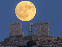 The Full Buck Moon rises behind the ancient Greek Temple of Poseidon on Cape Sounion in Greece on July 20, 2024 (