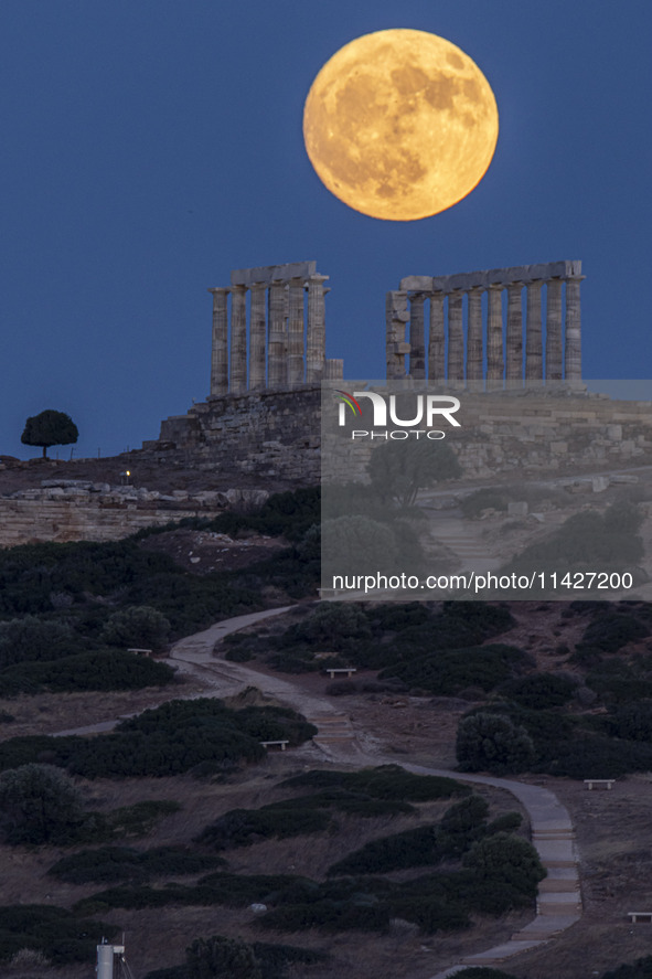 The Full Buck Moon rises behind the ancient Greek Temple of Poseidon on Cape Sounion in Greece on July 20, 2024 