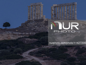 The Full Buck Moon rises behind the ancient Greek Temple of Poseidon on Cape Sounion in Greece on July 20, 2024 (