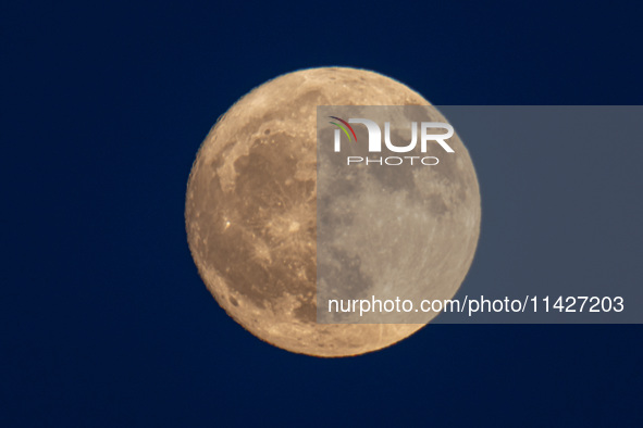 Close up at the Full Buck Moon rises behind the ancient Greek Temple of Poseidon on Cape Sounion in Greece on July 20, 2024 