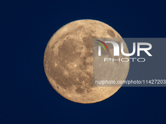 Close up at the Full Buck Moon rises behind the ancient Greek Temple of Poseidon on Cape Sounion in Greece on July 20, 2024 (