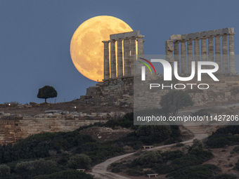 The Full Buck Moon rises behind the ancient Greek Temple of Poseidon on Cape Sounion in Greece on July 20, 2024 (