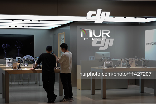 A staff member is introducing DJI products to a customer at a DJI drone shop in Shanghai, China, on July 22, 2024. 