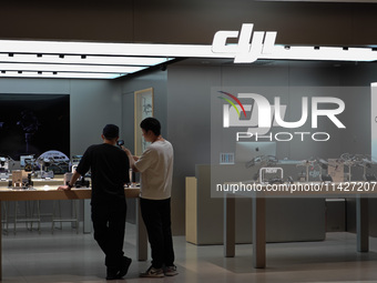 A staff member is introducing DJI products to a customer at a DJI drone shop in Shanghai, China, on July 22, 2024. (