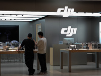 A staff member is introducing DJI products to a customer at a DJI drone shop in Shanghai, China, on July 22, 2024. (