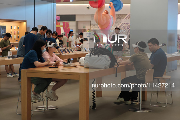 Customers are trying on and learning about Apple Vision Pro headsets at an Apple store in Shanghai, China, on July 22, 2024. 