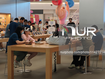 Customers are trying on and learning about Apple Vision Pro headsets at an Apple store in Shanghai, China, on July 22, 2024. (