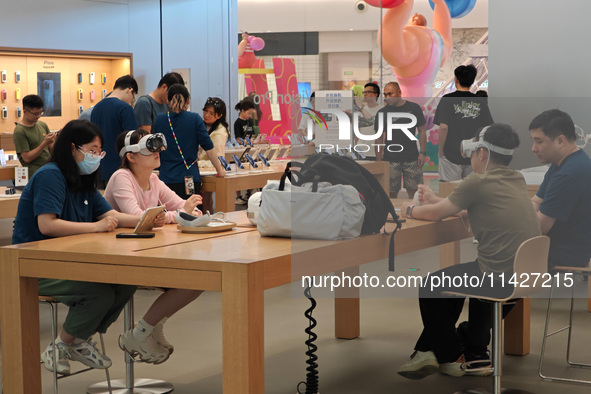 Customers are trying on and learning about Apple Vision Pro headsets at an Apple store in Shanghai, China, on July 22, 2024. 