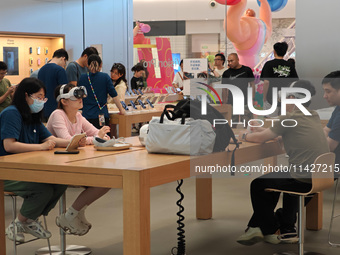 Customers are trying on and learning about Apple Vision Pro headsets at an Apple store in Shanghai, China, on July 22, 2024. (