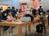 Customers are trying on and learning about Apple Vision Pro headsets at an Apple store in Shanghai, China, on July 22, 2024. (