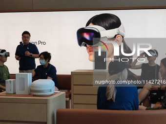 Customers are trying on and learning about Apple Vision Pro headsets at an Apple store in Shanghai, China, on July 22, 2024. (