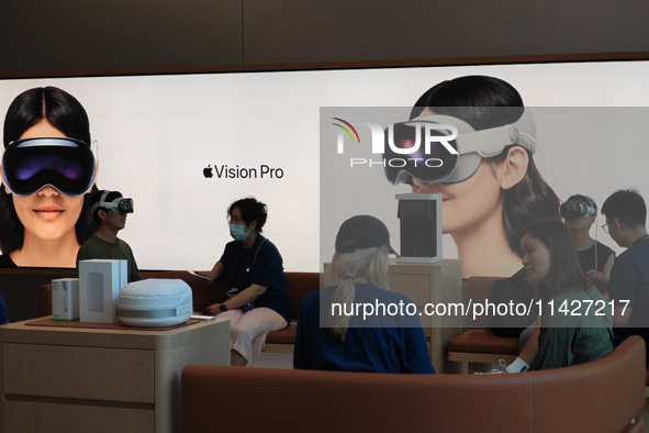 Customers are trying on and learning about Apple Vision Pro headsets at an Apple store in Shanghai, China, on July 22, 2024. 