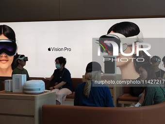 Customers are trying on and learning about Apple Vision Pro headsets at an Apple store in Shanghai, China, on July 22, 2024. (