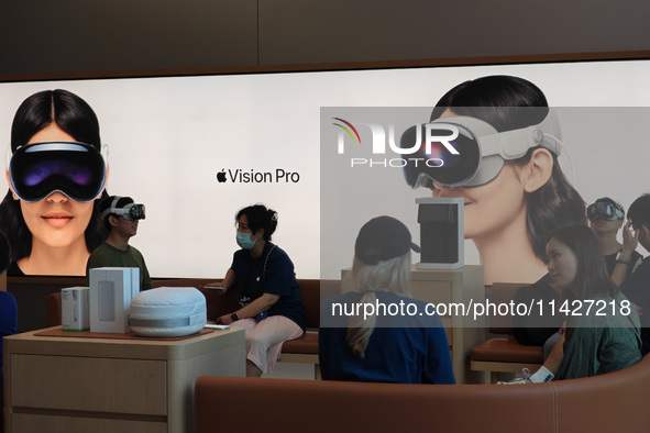 Customers are trying on and learning about Apple Vision Pro headsets at an Apple store in Shanghai, China, on July 22, 2024. 