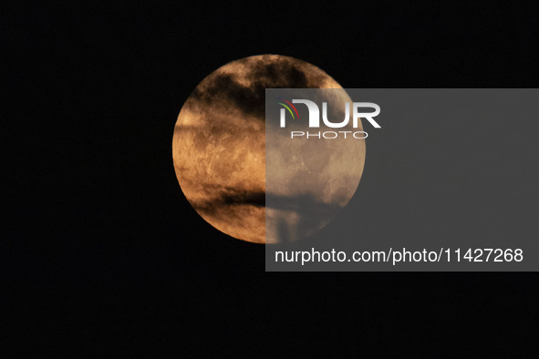 The Full Moon of July 2024 known as Buck Moon or Thunder Moon spotted behind clouds over Mount Olympus in Greece. Mount Olympus is a Nationa...