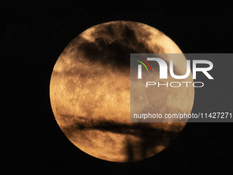 The Full Moon of July 2024 known as Buck Moon or Thunder Moon spotted behind clouds over Mount Olympus in Greece. Mount Olympus is a Nationa...