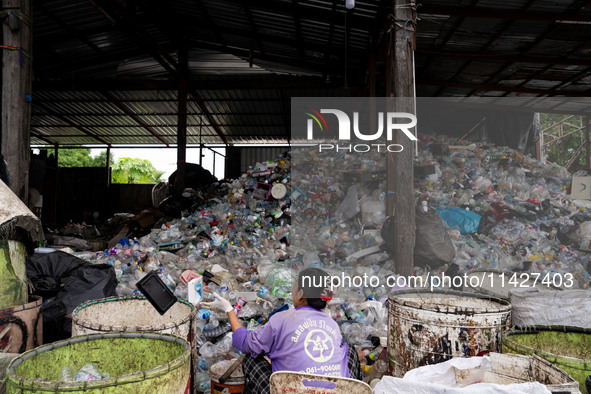 Burmese workers are sorting rotting food waste, fabric, and recyclable plastic by hand at a sorting facility in Bangkok, Thailand, on July 2...