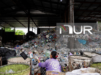 Burmese workers are sorting rotting food waste, fabric, and recyclable plastic by hand at a sorting facility in Bangkok, Thailand, on July 2...