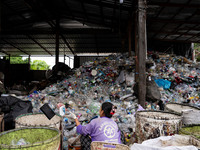 Burmese workers are sorting rotting food waste, fabric, and recyclable plastic by hand at a sorting facility in Bangkok, Thailand, on July 2...