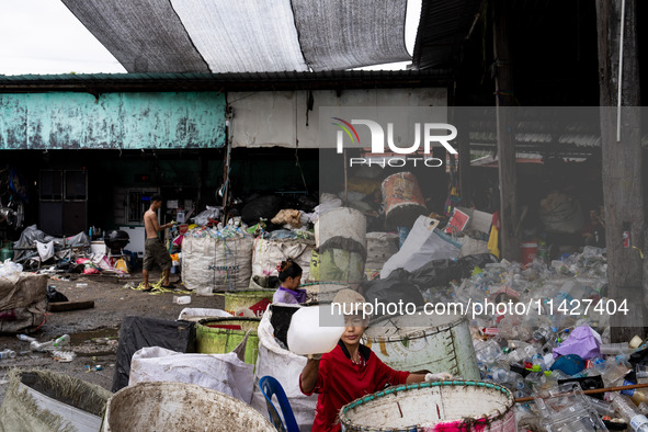 Burmese workers are sorting rotting food waste, fabric, and recyclable plastic by hand at a sorting facility in Bangkok, Thailand, on July 2...